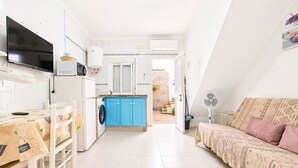 A compact living space with a kitchenette, a dining area, and a sofa. - Apartamento cerca de la playa de Conil (Conil de la Frontera)