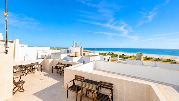 A rooftop terrace with outdoor seating and a view of the beach. - Apartamento cerca de la playa de Conil (Conil de la Frontera)