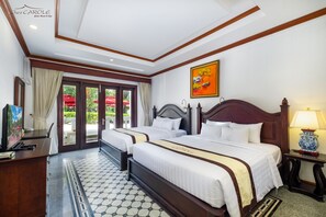 A hotel room with two beds, a desk, a chair, a lamp, and a painting.