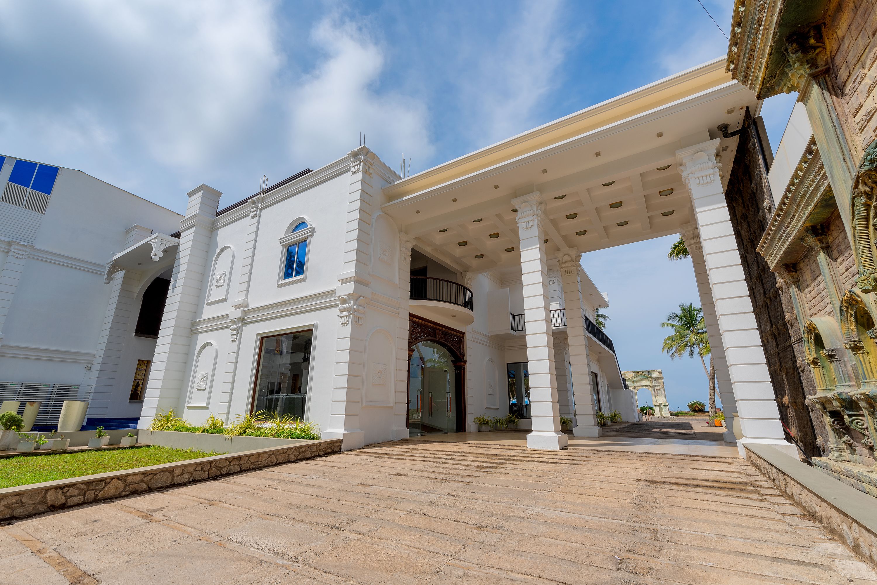 A grand building with a central entrance, large columns, and a covered walkway.
