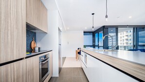Apartamento luxo, 2 quartos | Cozinha privada | Geladeira, micro-ondas, fogão, cooktop