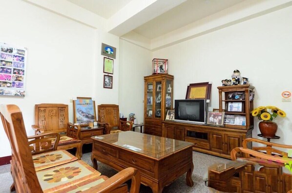 A traditional room with wooden furniture, a television, and various decorations. - Plum Inn 1 (Jiji)