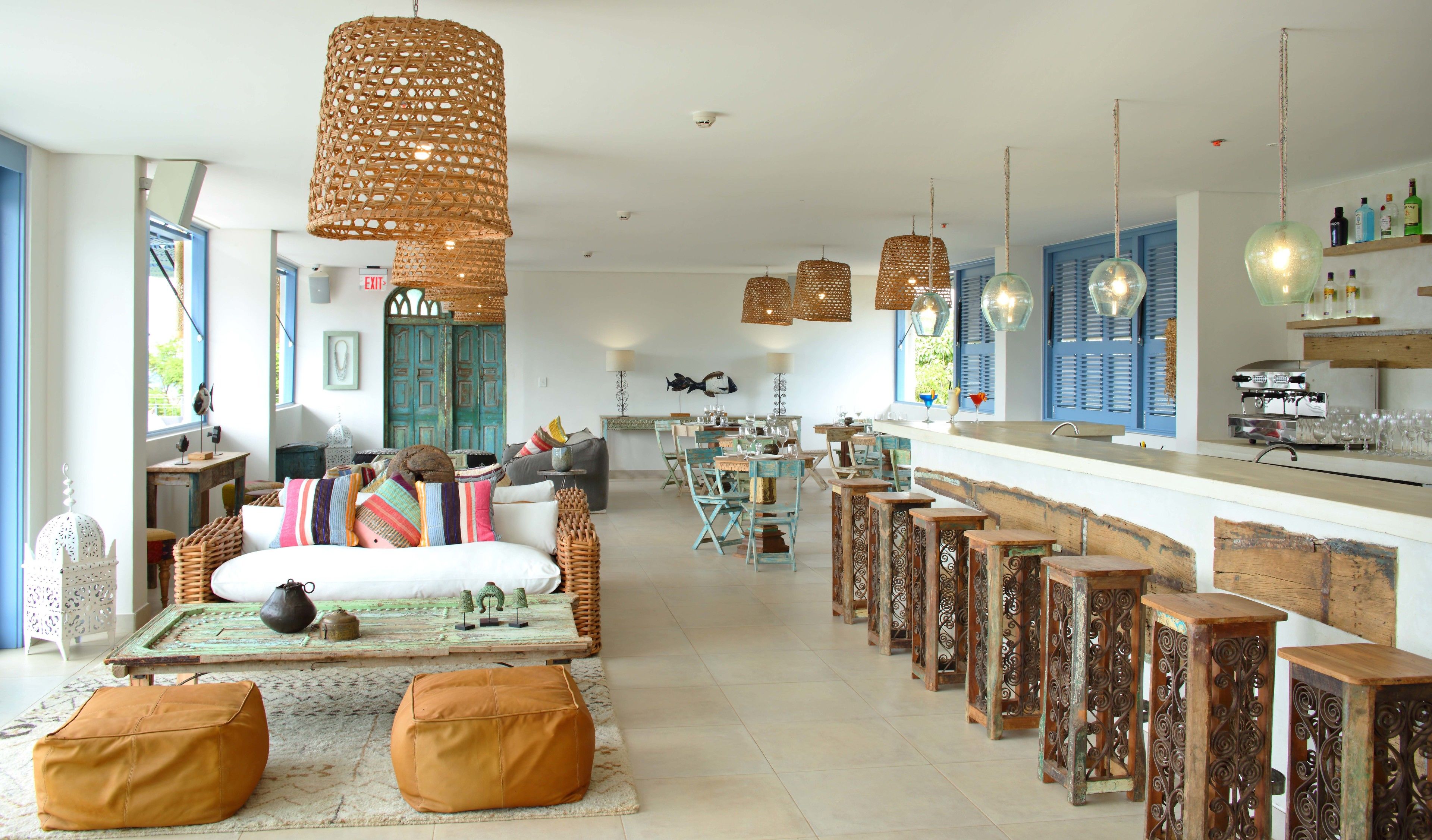 A spacious living area with a large sofa, ottomans, and a dining table set for a meal.