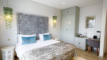 Een moderne slaapkamer met een groot bed, een bureau en een garderobe.