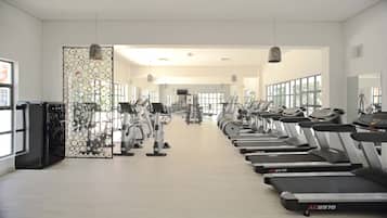 A gym with treadmills, elliptical machines, and free weights.