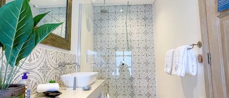 Un baño moderno con dos lavamanos, un espejo grande y baldosas con diseño.