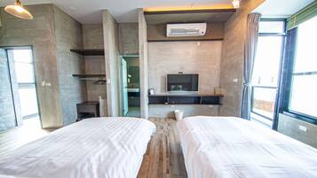 A modern hotel room with two beds, a TV, and a large window.