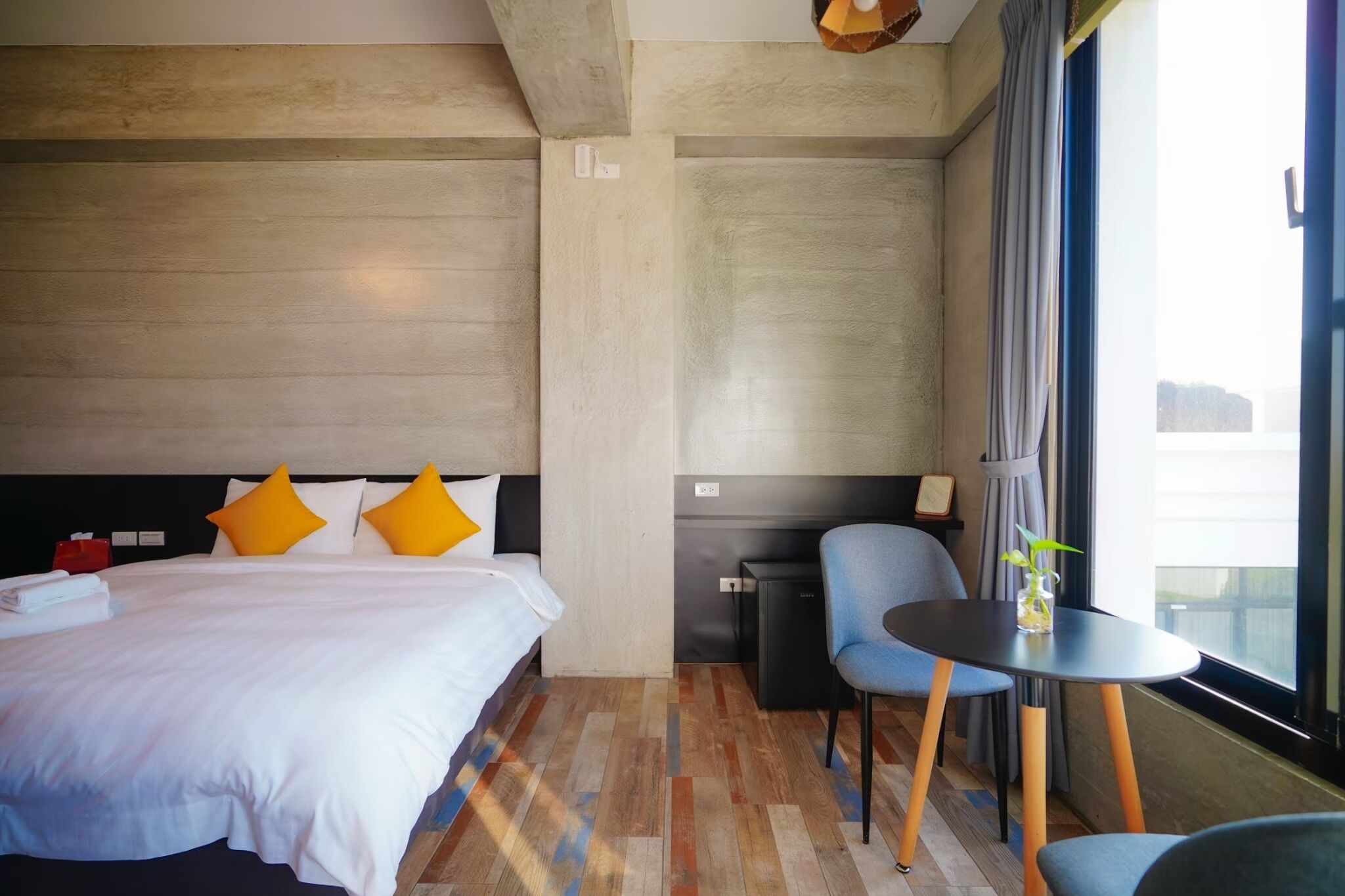 Una habitación de hotel con una cama, un escritorio y una silla.