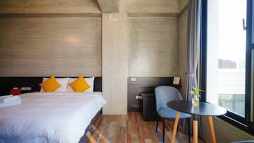 Una habitación de hotel con una cama, un escritorio y una silla.