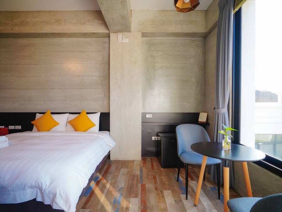 Una habitación de hotel con una cama, un escritorio y una silla.