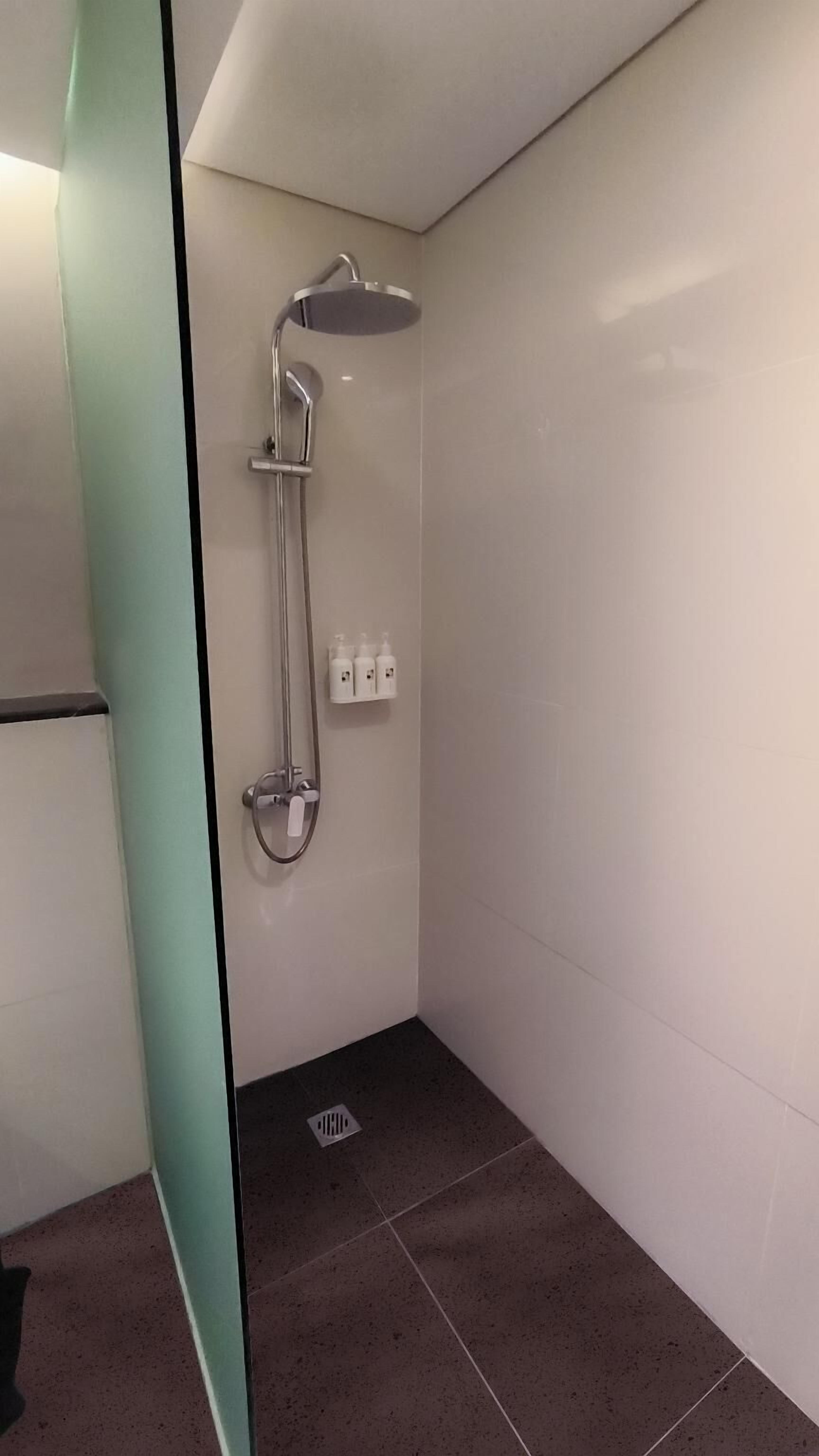 A modern bathroom with a shower, a toilet, and a sink.