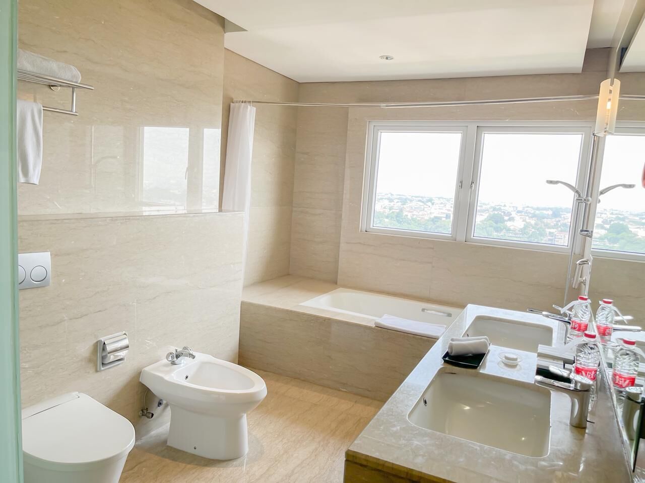 A modern bathroom with a bidet, toilet, bathtub, and sink.