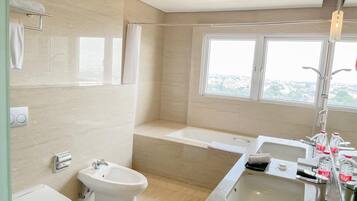 Une salle de bain moderne équipée d’un bidet, de toilettes, d’une baignoire et d’un lavabo.