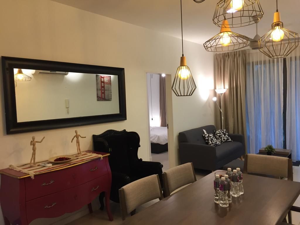 A hotel room with a dining area, a large mirror, a bed, and a window with curtains.