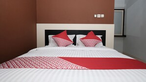 A bed with a white and red patterned bedspread, two red pillows, and a red throw blanket. - Hotel O Mars Kost Syariah (Jambi)