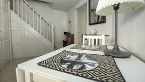 A staircase with white railings and a white wall.