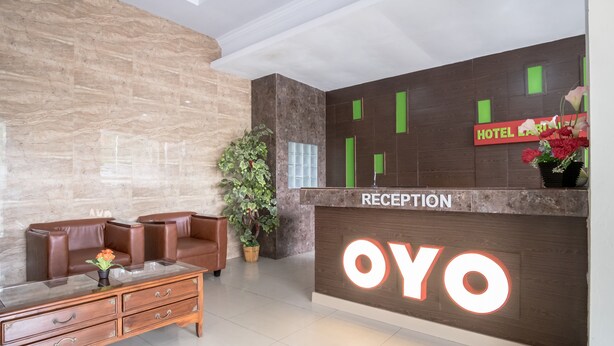 A reception area with a marble wall, a reception desk labeled "OYO," and a "HOTEL" sign above it. - Hotel O Medan Near Gajah Mada formerly Hotel Indah Raya (Medan)