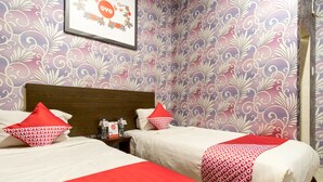 A hotel room with two beds, each with red and white patterned bedding, a wooden headboard, and a framed picture on the wall. - Hotel O Medan Near Gajah Mada formerly Hotel Indah Raya (Medan)
