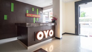A reception desk with a sign reading "HOTEL LABUHAN RAYA" and "RECEPTION" above it. - Hotel O Medan Near Gajah Mada formerly Hotel Indah Raya (Medan)