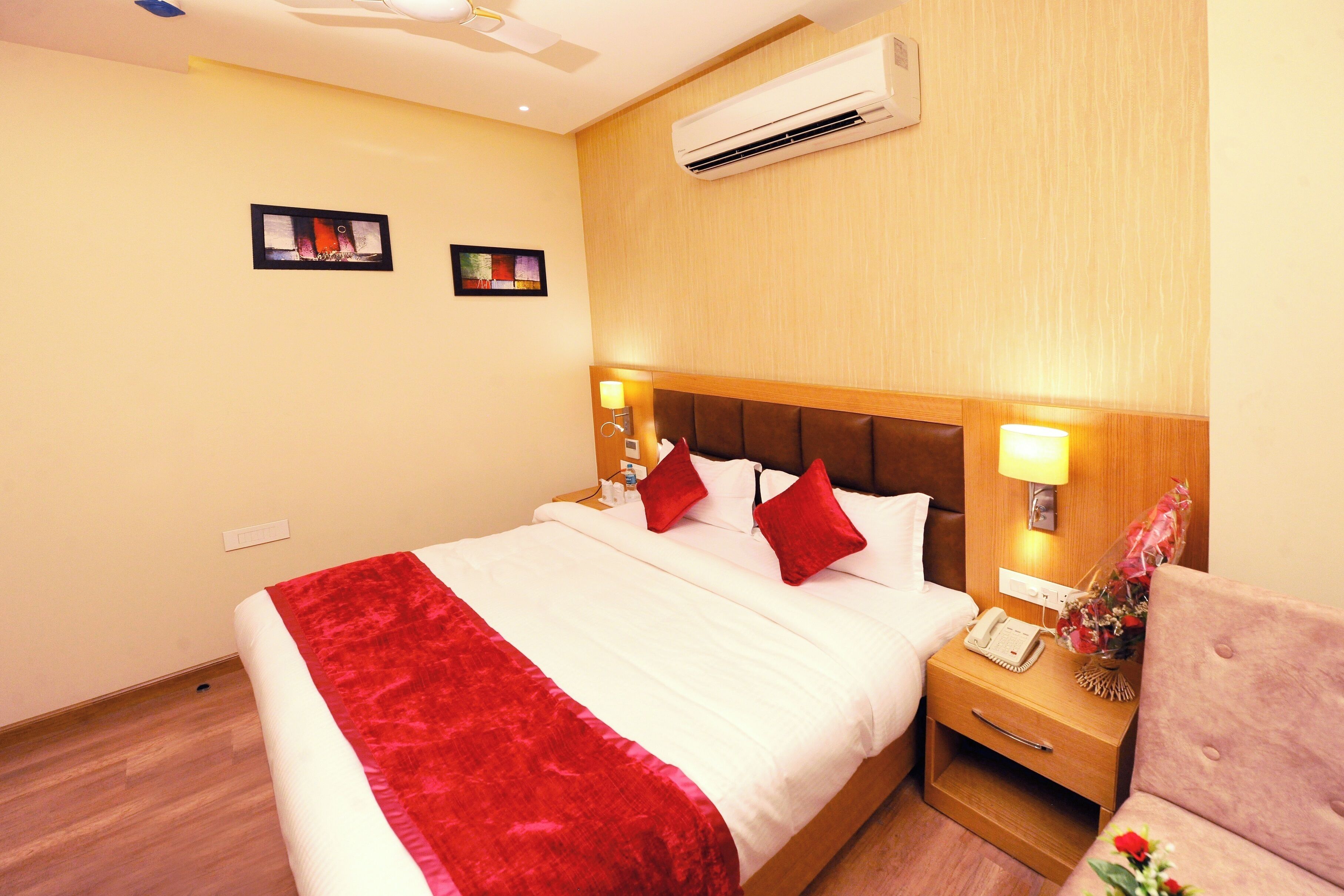 Ein Hotelzimmer mit Bett, Nachttisch und Klimaanlage.