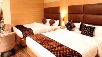 A hotel room with two beds, a wooden headboard, a nightstand, and a chair.