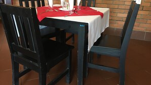 Mesa de comedor con mantel blanco, servilletas rojas y cristalería.