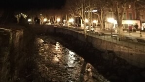 A nighttime view of a riverside promenade with trees and street lamps. - - Large cozy studio ---- (Puget-Théniers)