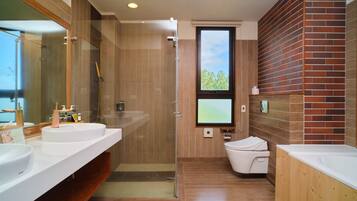 Un baño moderno con dos lavamanos, una cabina de ducha con mampara de vidrio, inodoro y un ventanal grande.
