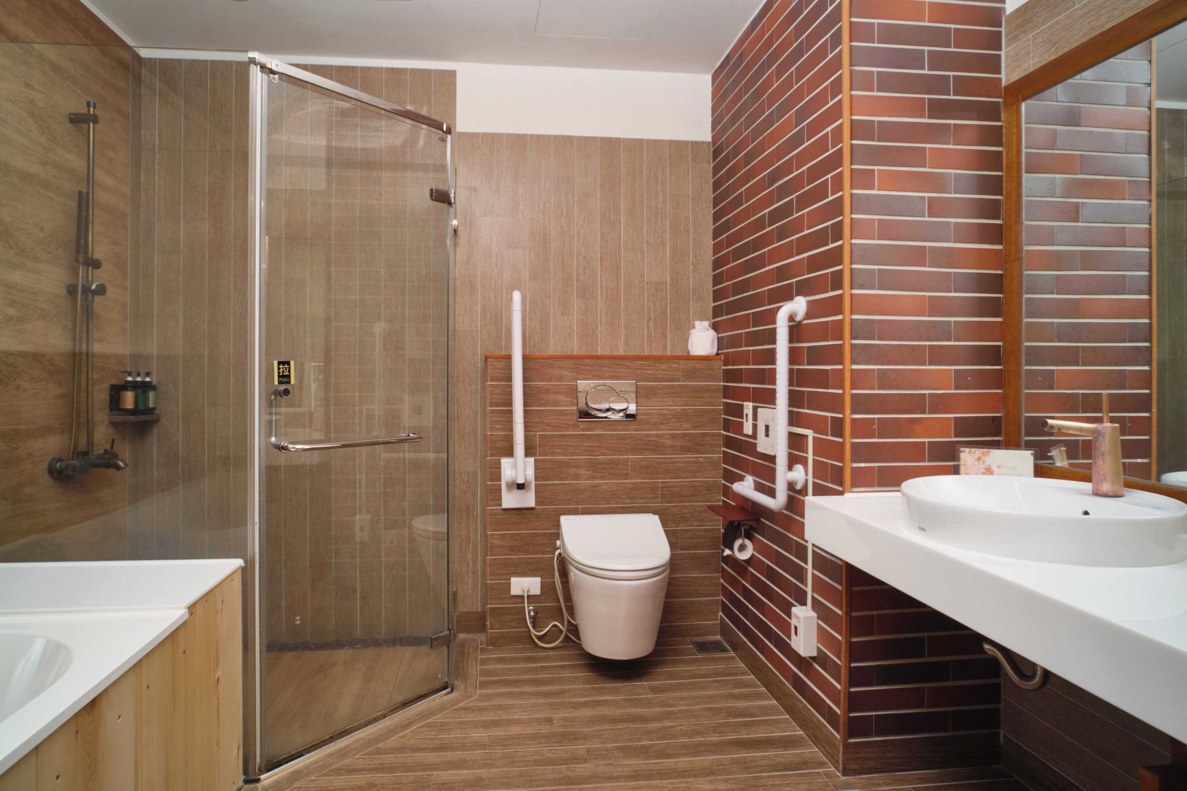 A modern bathroom with a glass shower enclosure, a white toilet, and a sink with a mirror.