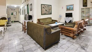 A living room with a sofa, a television, and a cabinet. - Guest House Near by Kebun Raya Bogor (Bogor)