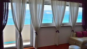 A room with a view of the sea, a sofa, and a window with curtains. - Apartments Mistral (Omis)