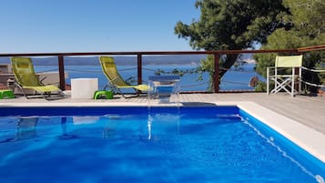 Outdoor pool, a heated pool, pool umbrellas, pool loungers