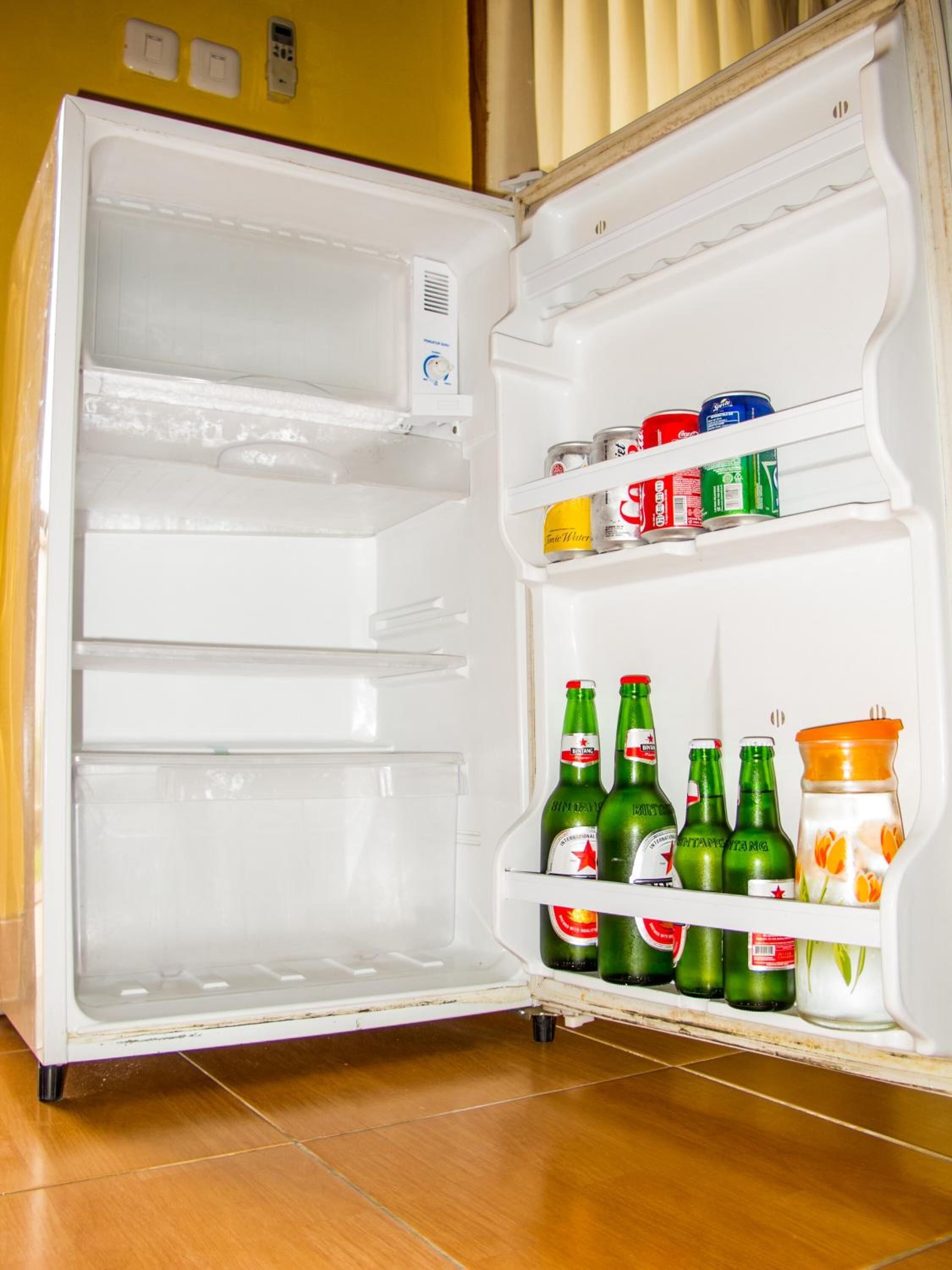 Ein offener Kühlschrank mit Regalen voller Getränke und Gewürzen.