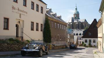 Une vue de rue avec une voiture ancienne garée devant un bâtiment portant l’inscription « Hôtel avec uniquement des suites ».