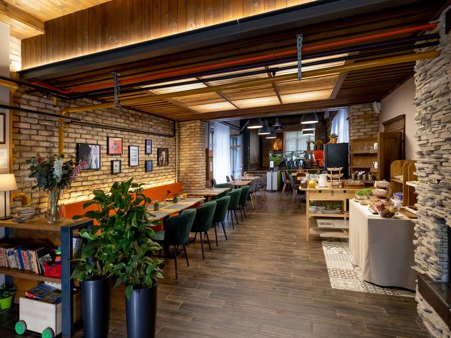 A modern restaurant with exposed brick walls, wooden ceilings, and a stone fireplace.