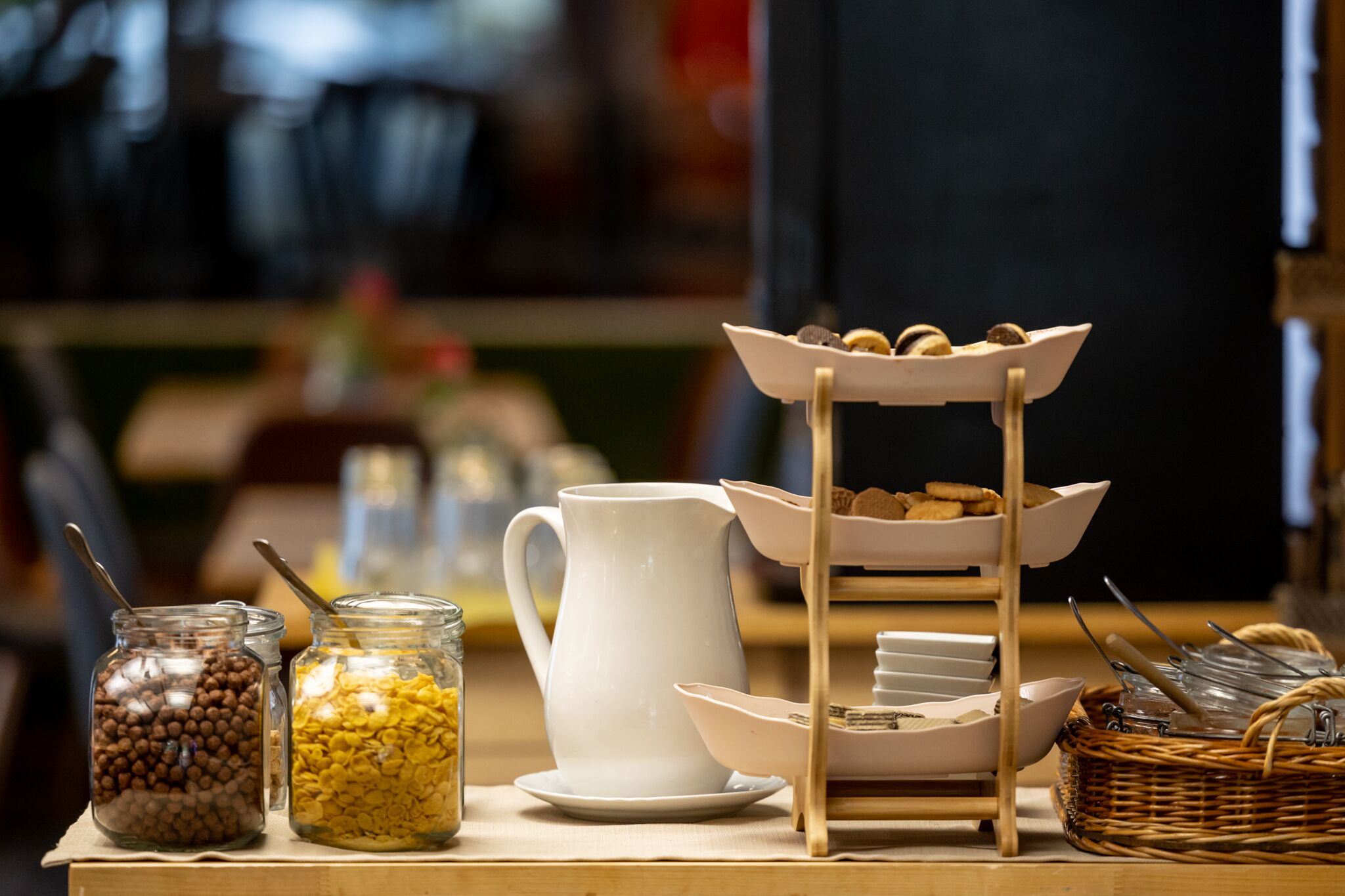 Ein Frühstücksbuffet mit Gläsern voller Granola, einer Kanne und einer Etage mit Gebäck.