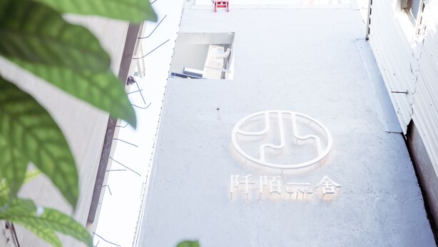 A building with a large, circular logo and Chinese characters on the facade. - Uns B&B (Kaohsiung)