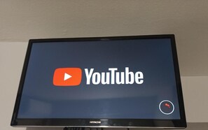 A flat-screen television displaying the YouTube logo. - Click & Room (Torremolinos)