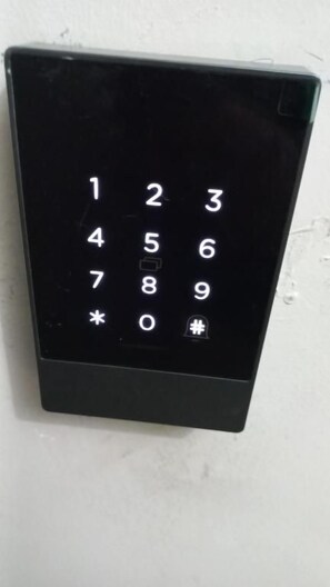A black numeric keypad mounted on a white wall. - Click & Room (Torremolinos)