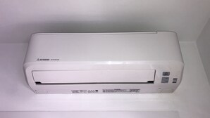 A Mitsubishi Inverter air conditioner unit mounted on a white wall.
