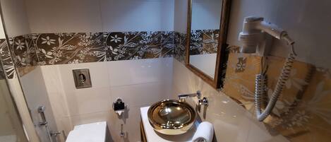 Une salle de bain avec des toilettes, un lavabo et un miroir.