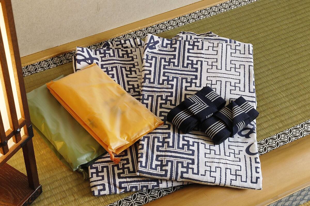 A wooden table with a patterned cushion, a green pillow, and a pair of striped socks.