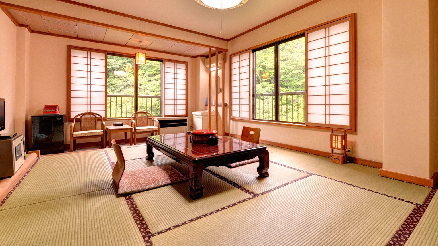 Una habitación japonesa tradicional con suelo de tatami, una mesa de madera baja y puertas correderas shoji.