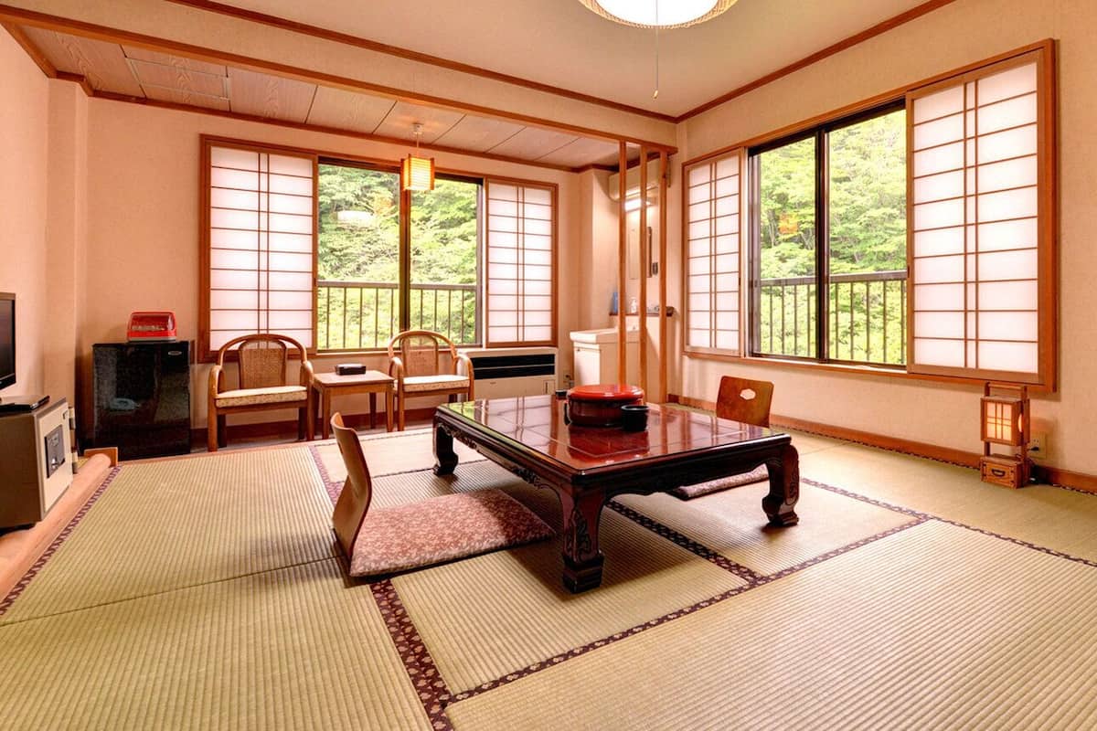 A traditional Japanese room with tatami flooring, a low wooden table, and sliding shoji doors.