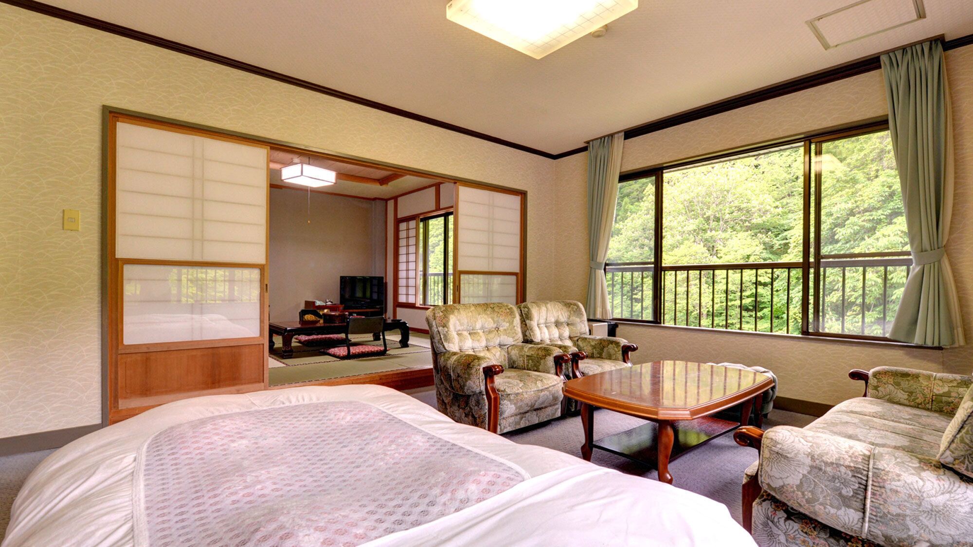 Una habitación tradicional japonesa con suelo de tatami, una mesa baja y dos futones de tatami.