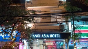 A hotel with a neon sign, outdoor seating, and a cafe. - Hanoi Asia Hotel (Hanoi)