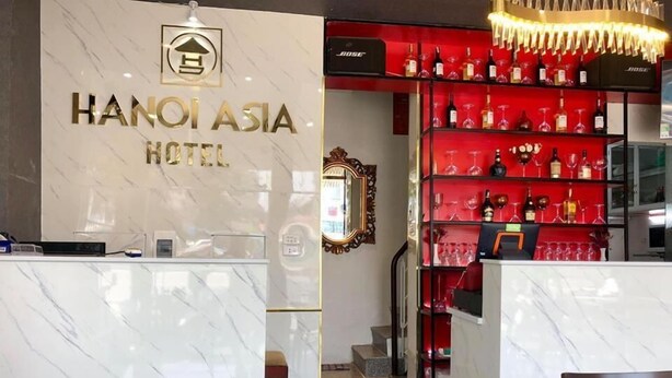 A reception area with a marble counter, a red wine rack, and a mirror. - Hanoi Asia Hotel (Hanoi)