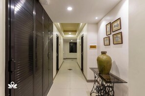 A hallway with closed doors, a central light fixture, and a table with a vase. - Casa Marita Vigan By Zuzu (Vigan)
