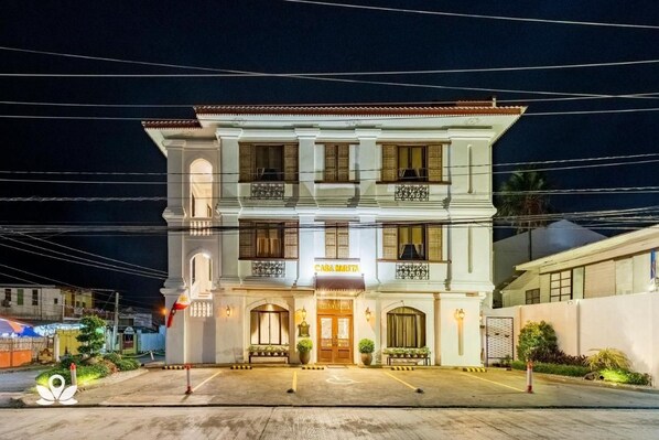 Un bâtiment à deux étages doté d’une entrée centrale, de balcons et d’une enseigne sur laquelle on peut lire « CASA MIBITA ».
