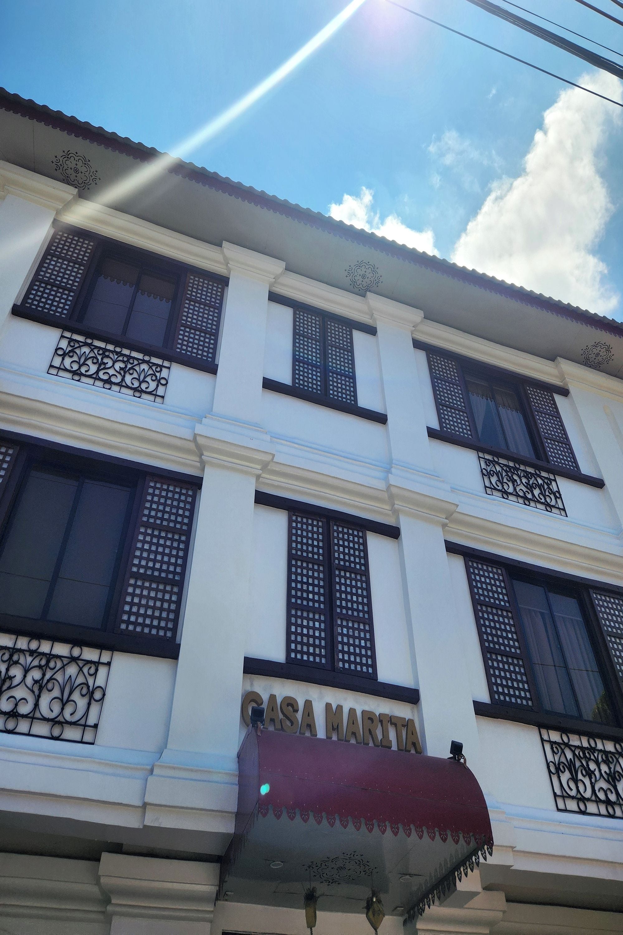 A building with the sign "CASA MARITA" and decorative ironwork on the windows.